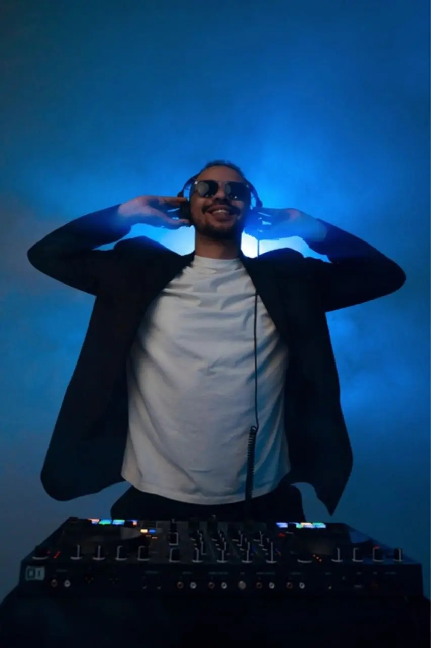 DJ Help am DJ-Pult im blauen Bühnenlicht