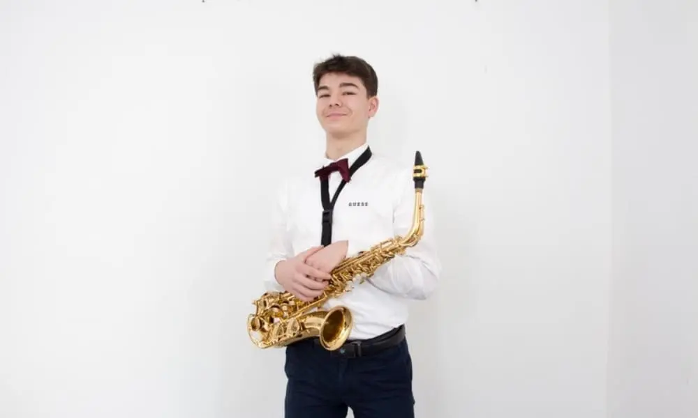 Saxofonist Artur im weißen Hemd mit Fliege und Saxofon - WeddingBro Events Saxofonist Artur im weißen Hemd mit Fliege und Saxofon