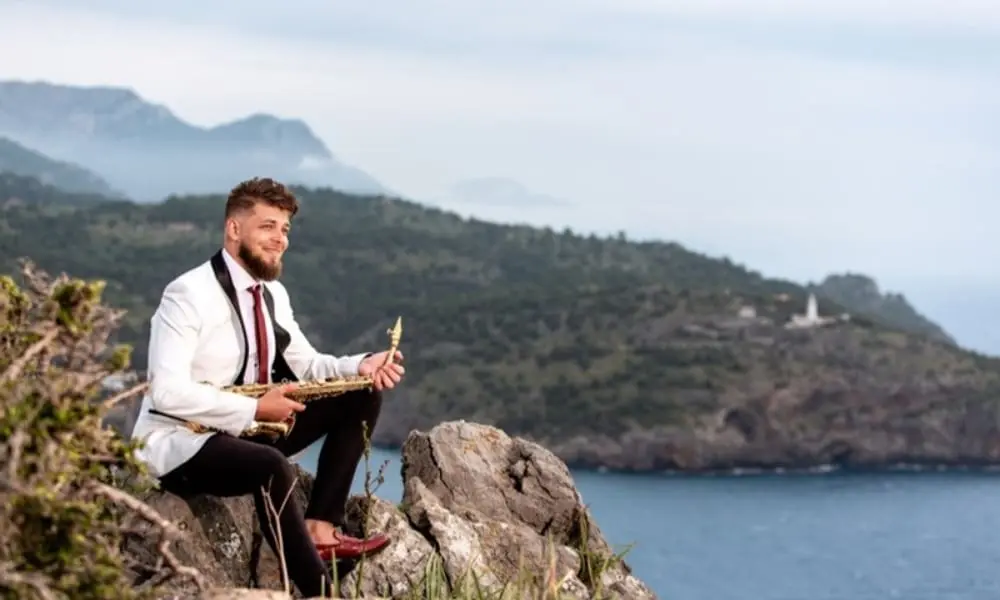 Saxofonist Vladimir im weißen Sakko bei einer Hochzeit im Freien - WeddingBro Events Saxofonist Vladimir im weißen Sakko bei einer Hochzeit im Freien